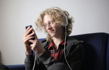 smiling-teenager-with-headphones-using-smartphone-3853937